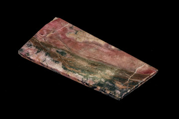 Macro stone Rhodonite mineral on a black background