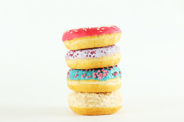 Vibrant composition of lush donut with colorful sprinkled icing, on bright background with a lot of copy space for text. Tasty but unhealthy food concept. Close up, flat lay, top view.