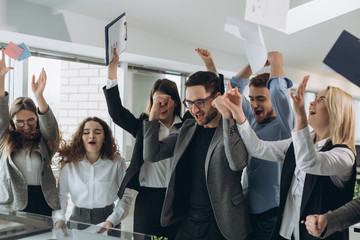 Group of business people celebrating by throwing their business papers and documents fly in air, Power of cooperation, Success teamwork concept