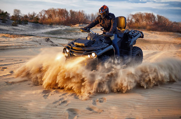 Racing in the sand on a four-wheel drive quad. © Bondariev Volodymyr.