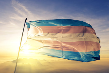Transgender pride flag waving on the top sunrise mist fog