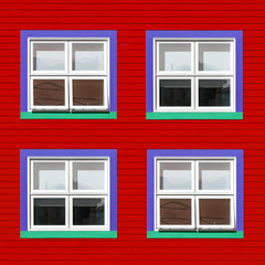 Purple and green windows on red wall