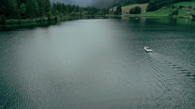 Aerial drone shot of family enjoying vacation or holiday during summer in alps or national park, use pedal boat or hydrocycle to explore glacier mountain lake. Concept green tourism