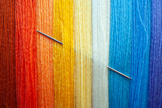 Many multi colored yarn strings for design background. Texture of colored thread with needle in it. Concept of sewing, hobby image.