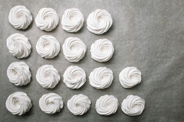 The process of making marshmallow. Close up hands of the chef with confectionery bag cream to parchment paper at pastry shop kitchen. The recipe for making marshmallow. Copy space