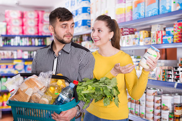 Obraz premium Couple with variety of products in shopping basket