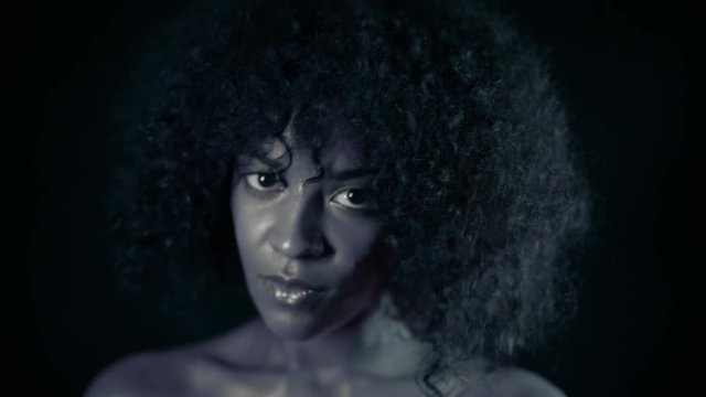 Black and white portrait of afro girl. Tempting woman with perfect makeup and curly hairstyle looking at camera and smiling. Glamour, fashion, model concept.