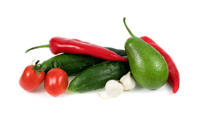 .avocado, peppers, cucumbers, tomatoes, and garlic on a white background..