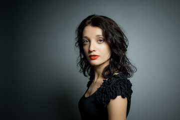 Naklejka premium Studio portrait of sexy brunette woman with red sensual lips looking at the camera posing on black background