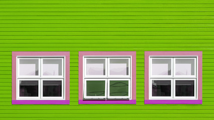 Pink and white windows on lime green wall