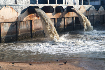 Industrial and factory waste water discharge pipe into the canal and sea, dirty water pollution