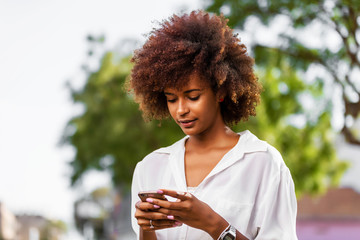 Outdoor portrait of a Young black African American young woman speaking on mobile phone
