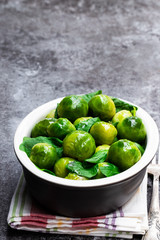 Cooked brussels sprouts with spinach on gray table