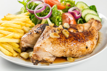 Zancas de pollo asado con patatas fritas y ensalada