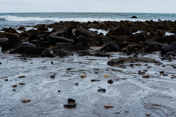 Dark rocks on the beach at low tide