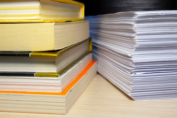 A stack of books and papers on the desktop, symbolizing learning, laws and regulations, a huge amount of information