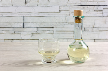Cruet of White Wine and Glass on a Wooden Table