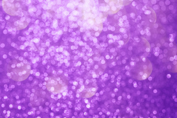 Abstract composition. Blurred photo of glitter with beautiful bokeh in purple. Defocused light.
