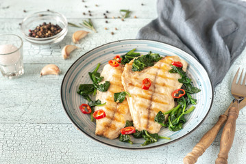 Grilled sea bream fish fillet with spinach - obrazy, fototapety, plakaty