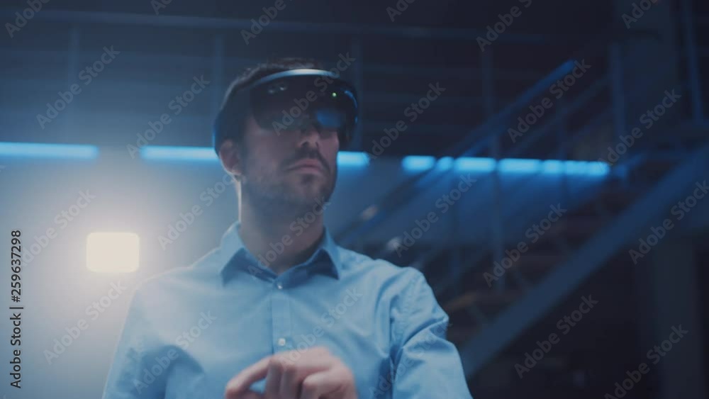 Poster In 3D Content Creating Laboratory Engineer Wearing Professional Virtual Reality Headset Works and Gestures in Augmented Reality. Stylish Low Angle Arc Portrait Shot 