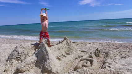 FUNNY BOY 6 YEARS ON THE SHORE OF THE SEA HAS BUILT A SAND CASTLE