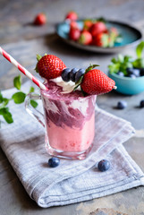 Strawberry and blueberry smoothie with yogurt, decorated with fruit skewer