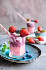 Strawberry and blueberry smoothie with yogurt, decorated with fruit skewer