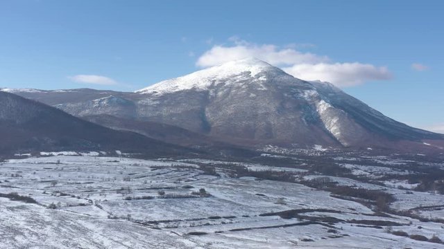 Valley in Eastern Serbia with Rtanj mountain under snow 4K drone video