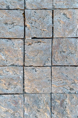 Granite cobblestoned pavement background. Fragment of a pavement along a street in Greece.