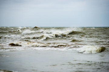 storm weather on the beach by rocky sea shore