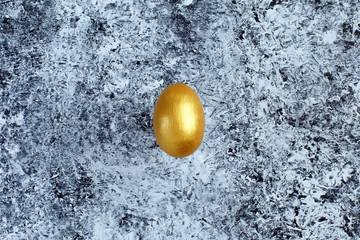 Golden egg, a symbol of making money and successful investment on abstract black and white...