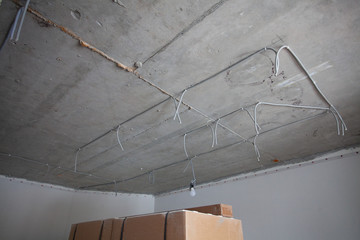 Cable laying on the ceiling. Electrical wires on the wall. Wiring replacement. Connecting the light in the flat or office. Professional installation of electrical outlets, wires and switches. 