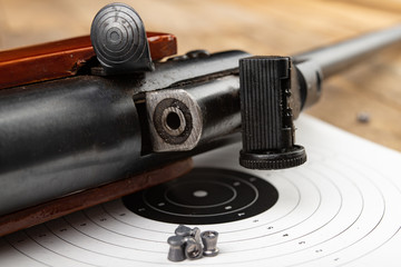 A pneumatic weapon on a wooden table on a shooting range. Shooting accessories needed for shooting...