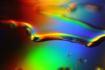 abstract liquid colorful background with water droplets and splash on holographic surface