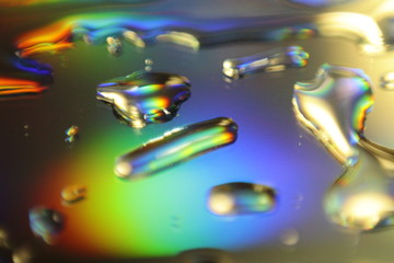 abstract holographic background with water drops on mirror surface