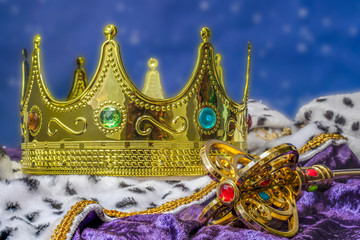 Royal robes, crown and scepter in front of a star field.