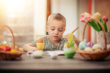 Cute little child painting Easter eggs