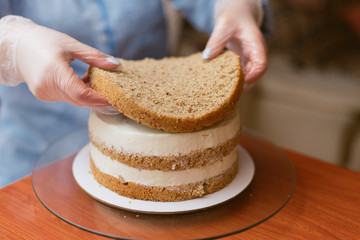 Pastry chef puts cake layer on a cake