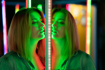 sweet caucasian girl walks in a mirror maze with colorful diodes and enjoys an unusual attraction...