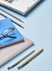 Notebooks, pencils, pens, glasses and computer are on the table