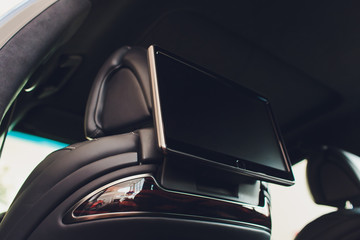 Car inside. Interior of prestige luxury modern car. Three TV displays for passenger with media...
