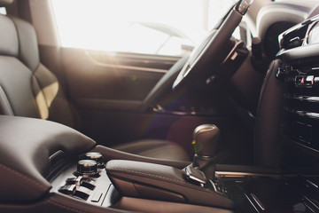 Dark luxury car Interior - steering wheel, shift lever and dashboard.