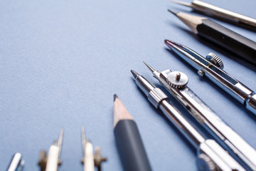 Compasses and pencils on a light blue background