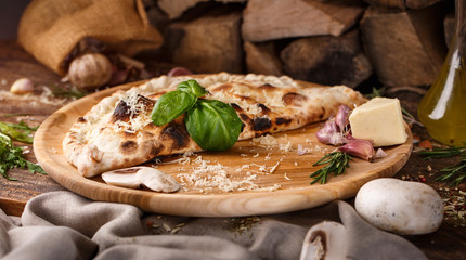 Harmonious composition of pizza Calzone, garlic, basil and cheese