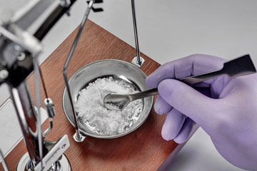 Pharmacist or scientist preparing medicine using precision weighing