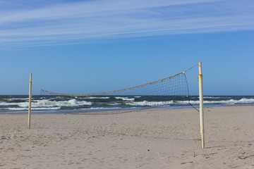 Volleyball net at the Baltic sea beach on sunny spring day