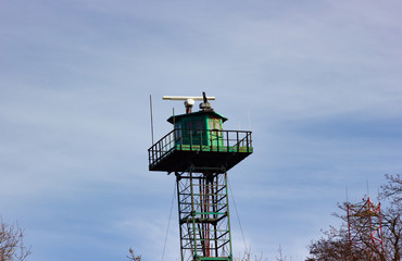 Metal green radio tower on the Baltic sea beach