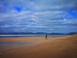 Scenic view of man running on the beach against blue sky 