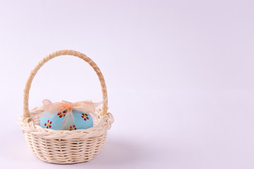 Fototapeta na wymiar Happy Easter. Easter eggs concept. Closeup Easter eggs in the basket on white paper background.
