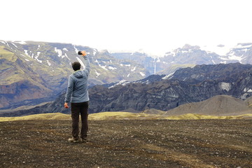 Fototapeta na wymiar Tourist taking photos of landscape near Katlan volcano in Iceland